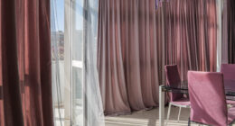 The sunlight through the fabric shade curtains on daytime. Summer and sunny day in a living room concept.